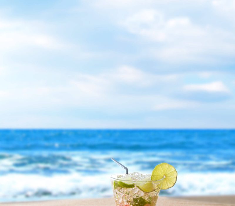 Cocktail with fresh lime and strawberry at the beach